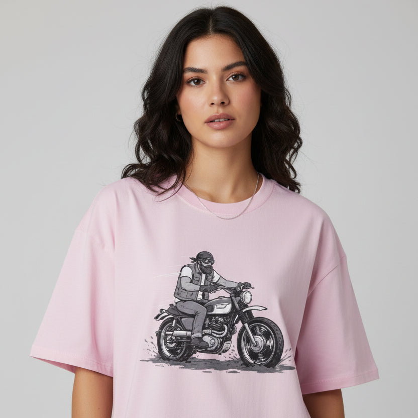 Woman wearing a pink t-shirt with a graphic of a person on a motorcycle.